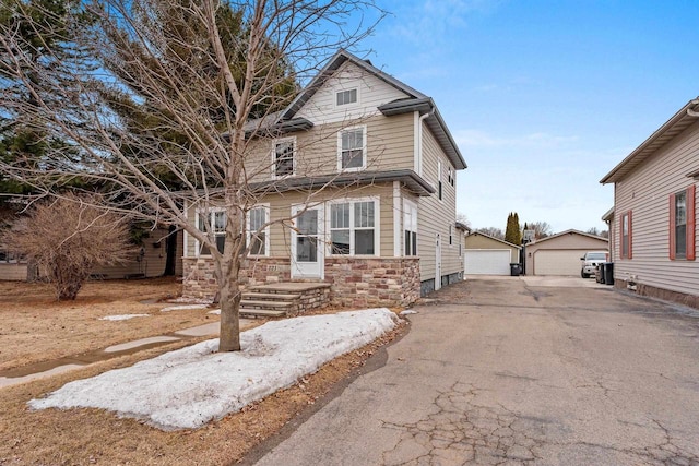 221 E 5th St, Shawano, WI 54166 - traditional style home with a detached garage, an outdoor structure, and stone siding