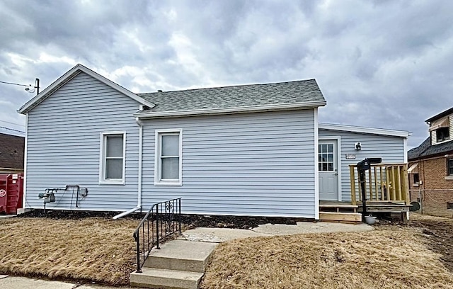 rear view of house with a shingled roof