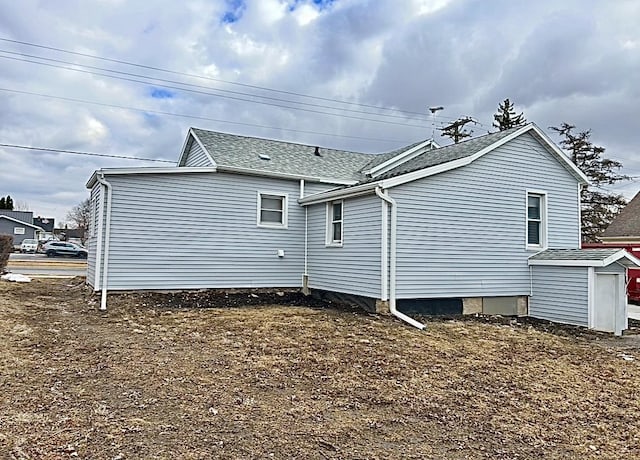 view of side of property with a shingled roof