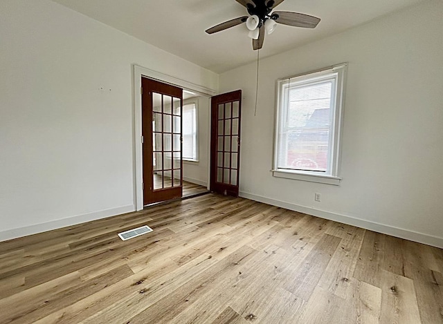 unfurnished room with ceiling fan, light wood finished floors, visible vents, and baseboards