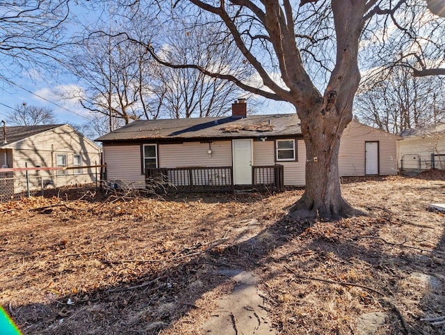 view of front of home with a chimney and fence