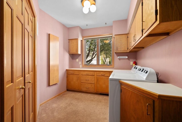 laundry room with light colored carpet, washer and dryer, cabinet space, and baseboards