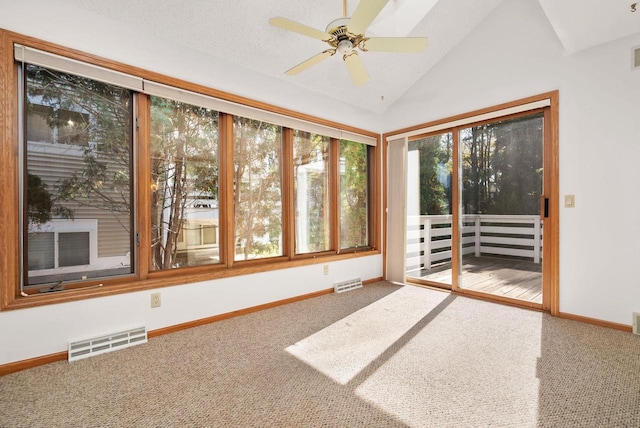 unfurnished sunroom with lofted ceiling, visible vents, and a ceiling fan