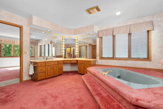 bathroom with visible vents, a jetted tub, vanity, and wallpapered walls