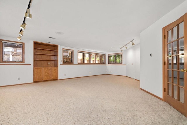 spare room featuring visible vents, rail lighting, and baseboards