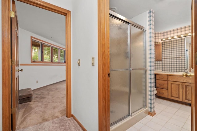 full bathroom featuring a stall shower, tile patterned flooring, vanity, and baseboards