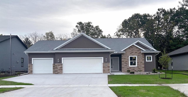 craftsman house with a garage, driveway, a front lawn, and stone siding