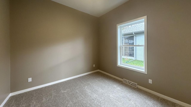 carpeted empty room with visible vents and baseboards