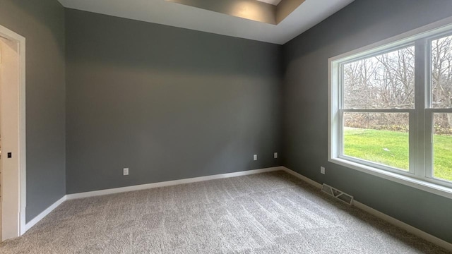 carpeted empty room featuring visible vents and baseboards