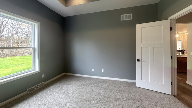 empty room with a wealth of natural light, visible vents, and baseboards