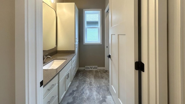 bathroom featuring visible vents, vanity, and baseboards