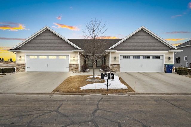 view of front facade featuring stone siding, an attached garage, and concrete driveway