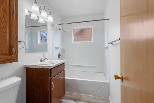 bathroom with toilet, wood finished floors, bathtub / shower combination, and vanity