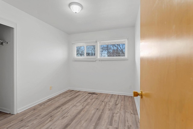 empty room with light wood-style floors and baseboards