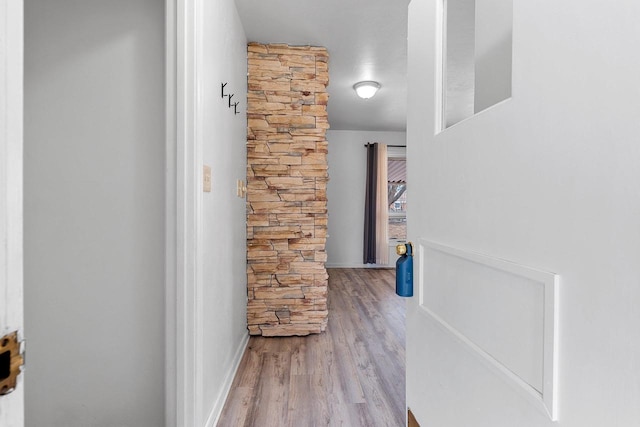 hallway with baseboards and wood finished floors