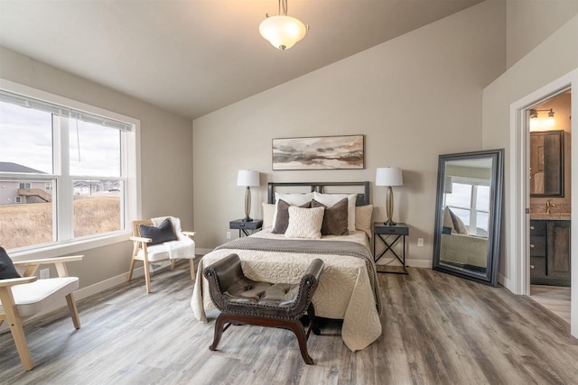 bedroom featuring vaulted ceiling, baseboards, and wood finished floors