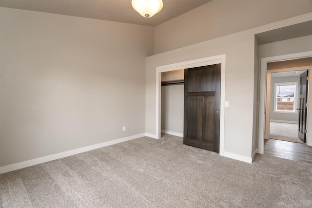 unfurnished bedroom with carpet, a closet, and baseboards