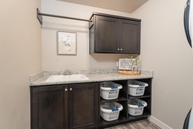 interior space with wood finished floors, a sink, and baseboards