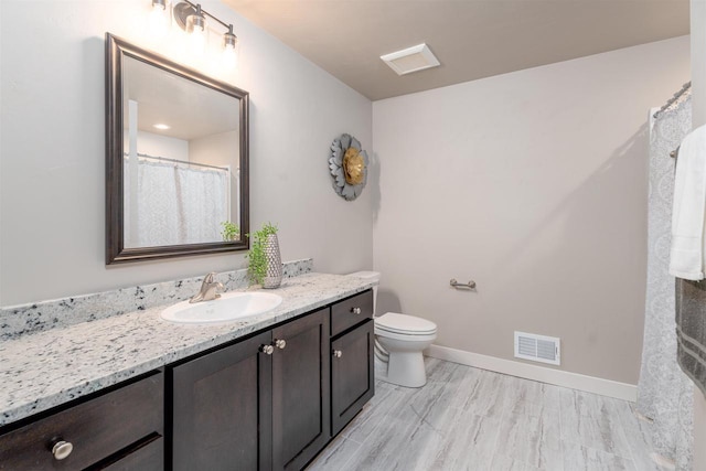 full bath with visible vents, toilet, vanity, and baseboards