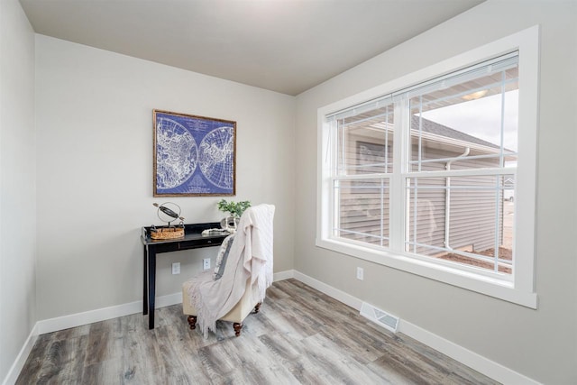 home office with wood finished floors, visible vents, and baseboards