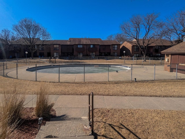 view of pool featuring fence and a residential view