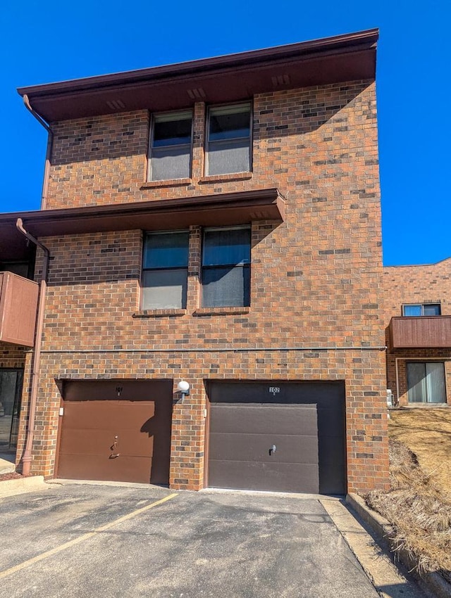 view of front of property with an attached garage and brick siding