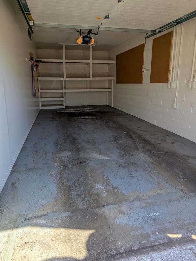 garage featuring a garage door opener and concrete block wall