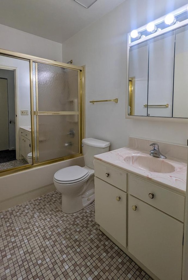 bathroom with toilet, shower / bath combination with glass door, tile patterned floors, and vanity