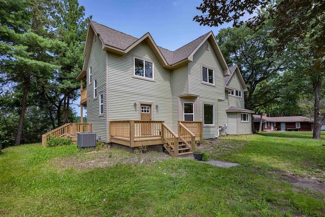 rear view of house with central AC, a lawn, a wooden deck, and roof with shingles