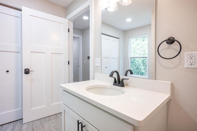 bathroom featuring a textured wall and vanity