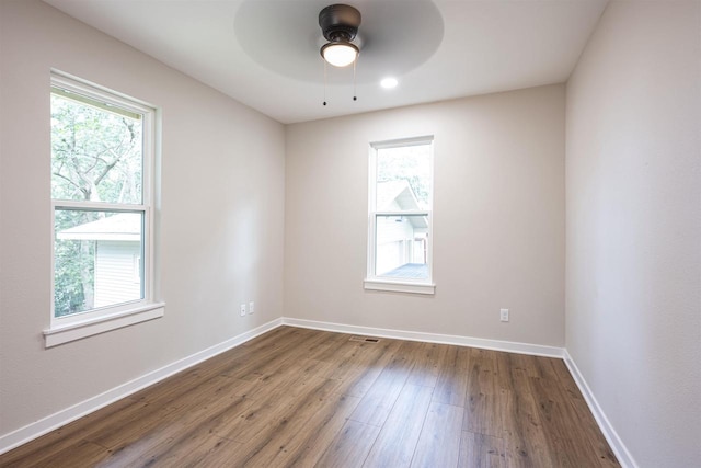 unfurnished room with plenty of natural light, baseboards, ceiling fan, and wood finished floors