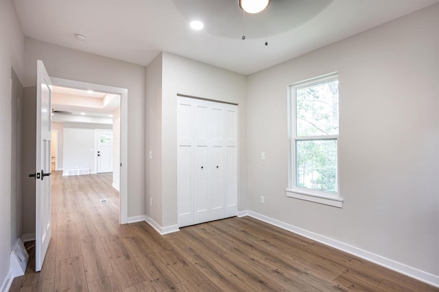 unfurnished bedroom featuring multiple windows and wood finished floors