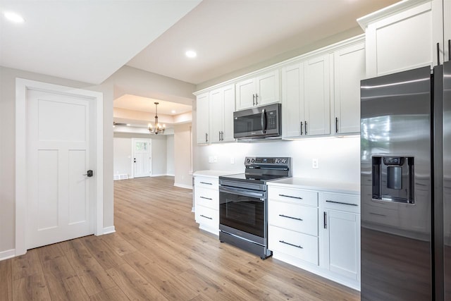 kitchen with stainless steel appliances, light countertops, light wood-style flooring, and baseboards