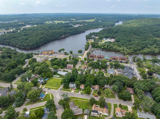 birds eye view of property with a water view and a wooded view