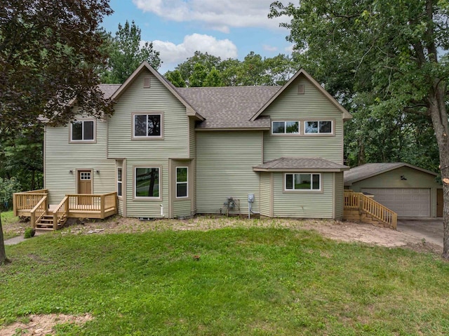 back of property with an outbuilding, roof with shingles, a lawn, and a garage