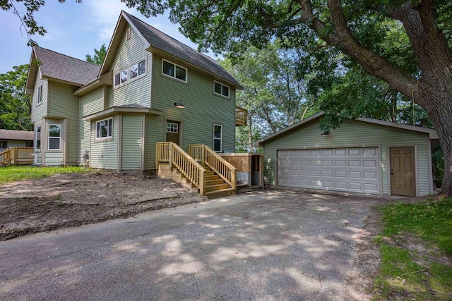 view of front of home with a detached garage and an outbuilding