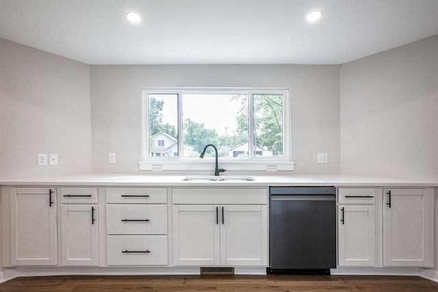 kitchen with recessed lighting, a sink, white cabinets, light countertops, and dishwasher