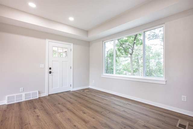 entrance foyer with baseboards, visible vents, and wood finished floors