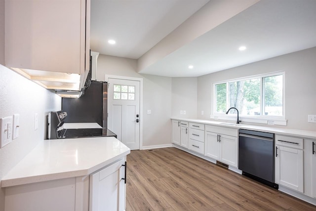 kitchen with appliances with stainless steel finishes, a wealth of natural light, white cabinetry, and light wood finished floors