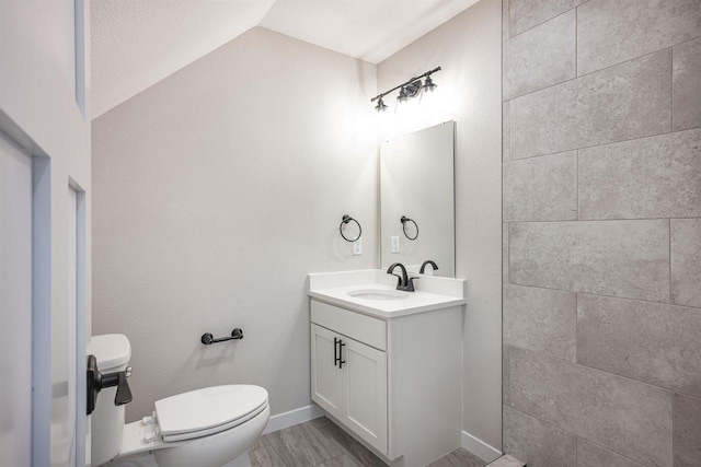 bathroom with marble finish floor, vanity, toilet, and baseboards