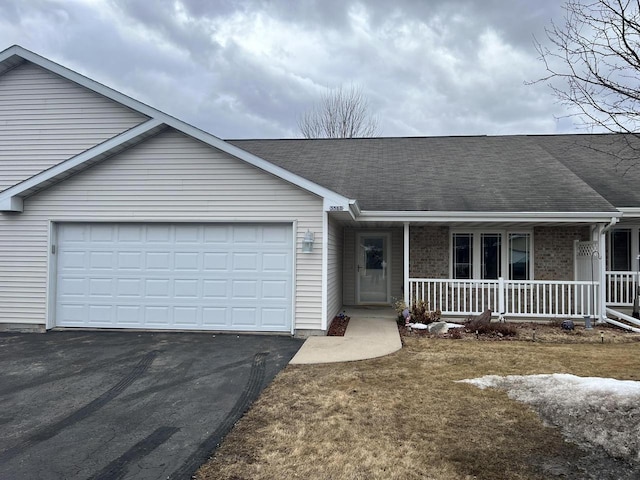 single story home with brick siding, roof with shingles, covered porch, a garage, and driveway