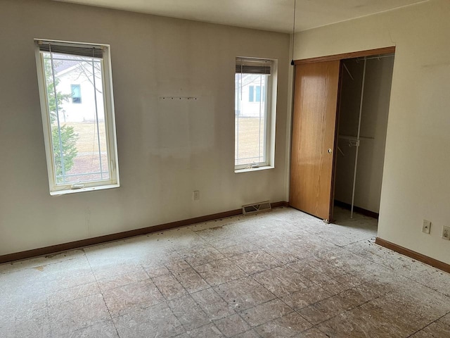 unfurnished bedroom featuring baseboards, visible vents, and a closet