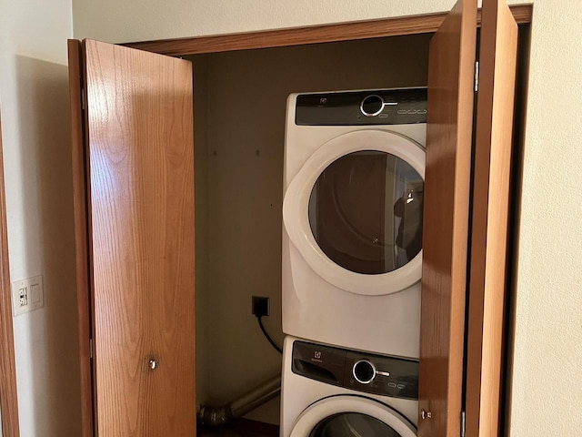 clothes washing area featuring laundry area and stacked washing maching and dryer