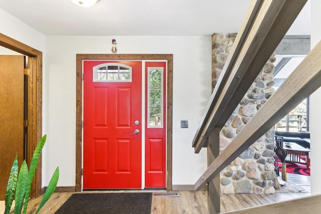 interior space featuring visible vents, a healthy amount of sunlight, baseboards, and wood finished floors