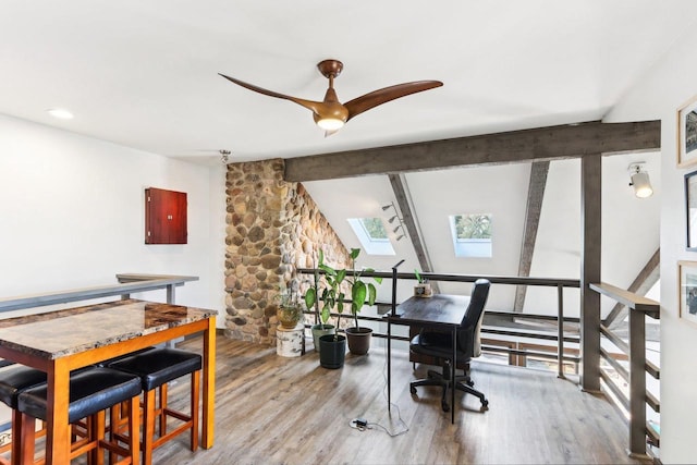 office space with lofted ceiling with skylight, wood finished floors, and ceiling fan