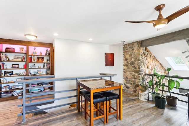 dining space featuring recessed lighting, lofted ceiling with skylight, and wood finished floors