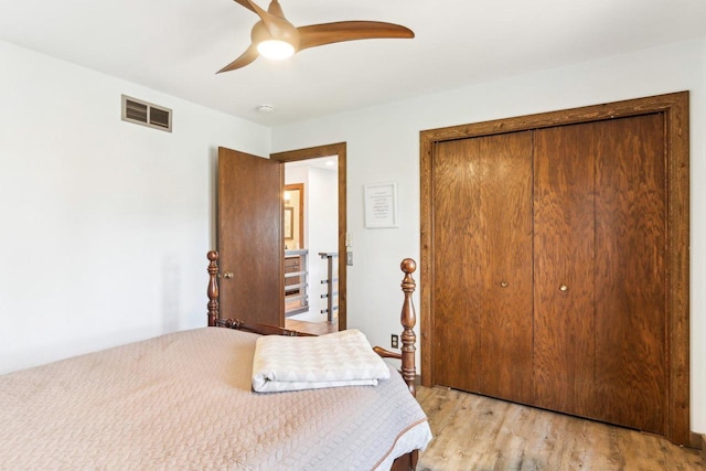 bedroom with a closet, visible vents, ceiling fan, and light wood-style floors