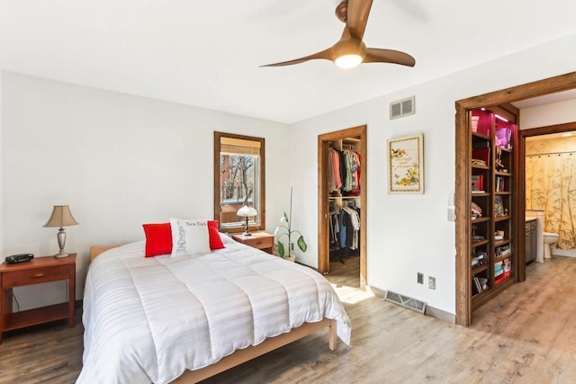 bedroom featuring visible vents, light wood-style floors, a closet, and a spacious closet