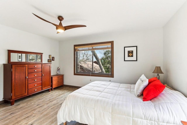 bedroom with baseboards, light wood-style floors, and a ceiling fan