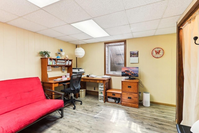 office space with baseboards, a paneled ceiling, and wood finished floors